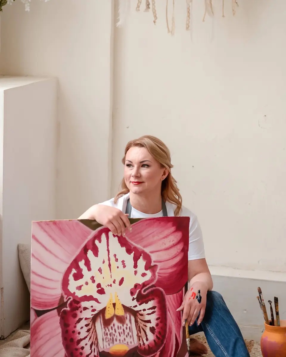 Юлія Сатир тримає свою картину орхідеї